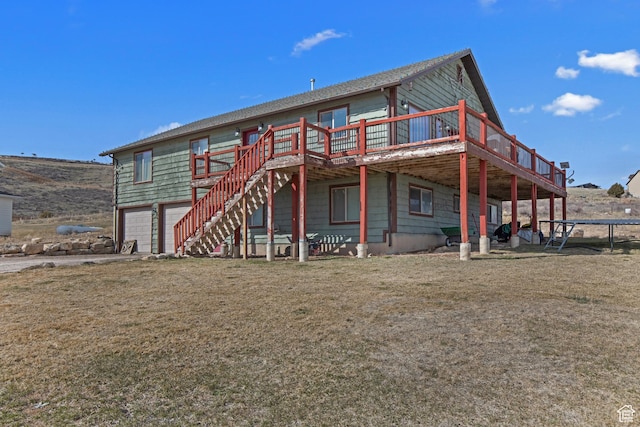 671 W Dee Dr, Garden City, UT 84028 - back of property with a yard, stairs, a trampoline, a garage, and a deck