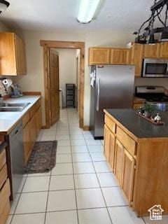 87 N Loafer Canyon Rd, Elk Ridge, UT 84651 - kitchen featuring stainless steel appliances, light tile patterned floors, a sink, and dark countertops