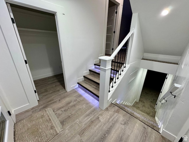 staircase with visible vents, baseboards, and wood finished floors