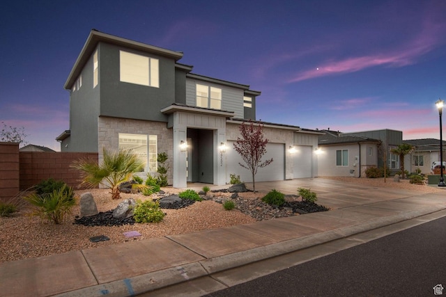 4582 S Sophia Ln, Washington, UT 84780 - modern home with concrete driveway, stucco siding, stone siding, a garage, and fence