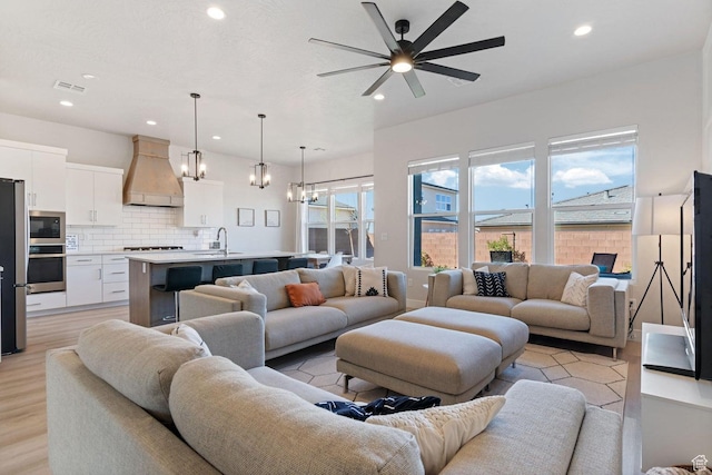 4582 S Sophia Ln, Washington, UT 84780 - living area with visible vents, light wood-type flooring, recessed lighting, and ceiling fan with notable chandelier