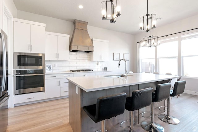 4582 S Sophia Ln, Washington, UT 84780 - kitchen featuring custom exhaust hood, a notable chandelier, decorative backsplash, stainless steel appliances, and a sink