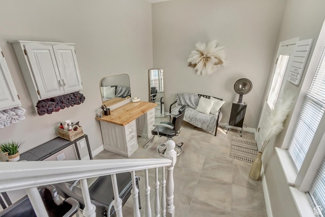 interior space with light tile patterned floors, baseboards, and a healthy amount of sunlight