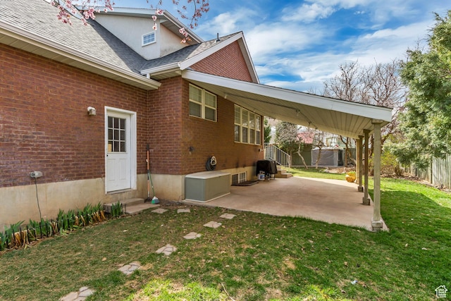 back of property with brick siding, entry steps, fence, and a lawn