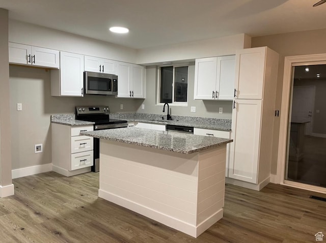 3977 W 5625 S, Roy, UT 84067 - kitchen featuring a kitchen island, stainless steel appliances, baseboards, and white cabinetry