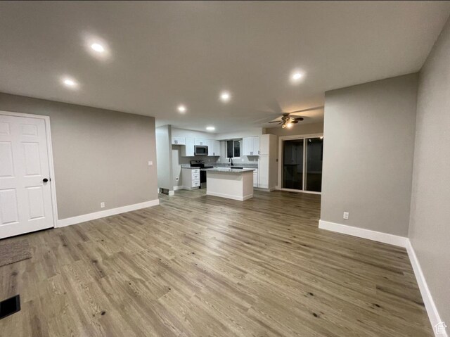 3977 W 5625 S, Roy, UT 84067 - unfurnished living room with recessed lighting, baseboards, ceiling fan, and light wood-type flooring
