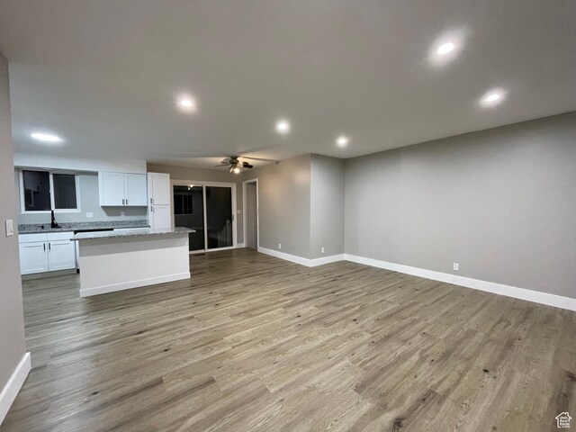 kitchen featuring a kitchen island, open floor plan, light wood-style floors, and ceiling fan