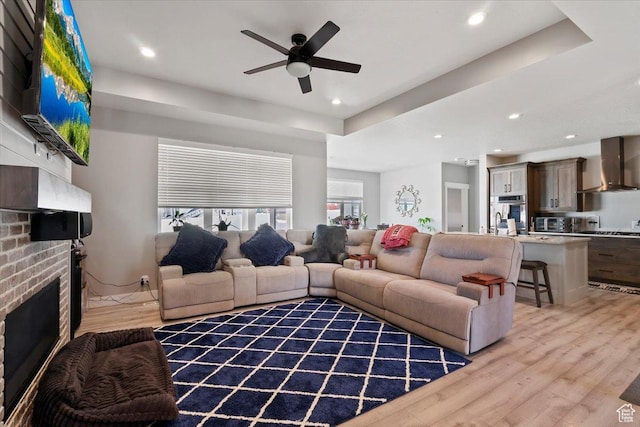 393 S Corner View Dr, Tooele, UT 84074 - living area featuring light wood-style flooring, ceiling fan, a brick fireplace, and recessed lighting