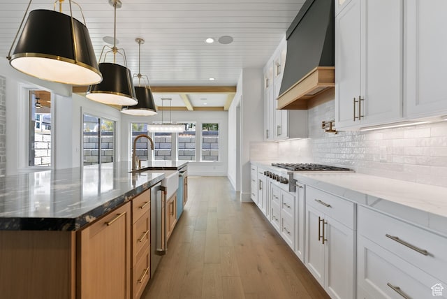1682 N 2250 W, Provo, UT 84604 - kitchen with light stone countertops, a sink, decorative backsplash, custom exhaust hood, and hardwood / wood-style flooring