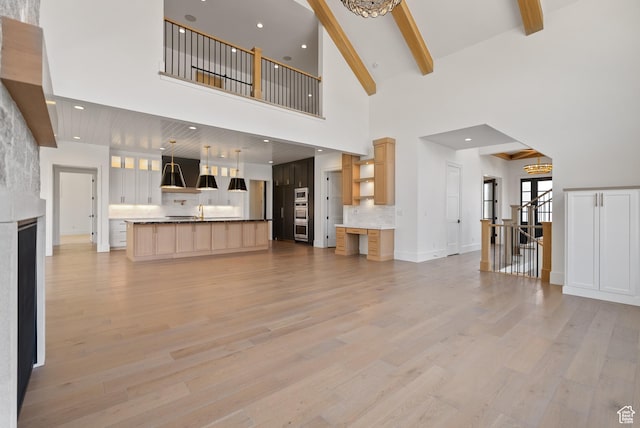 1682 N 2250 W, Provo, UT 84604 - unfurnished living room featuring light wood finished floors, beam ceiling, a notable chandelier, and high vaulted ceiling