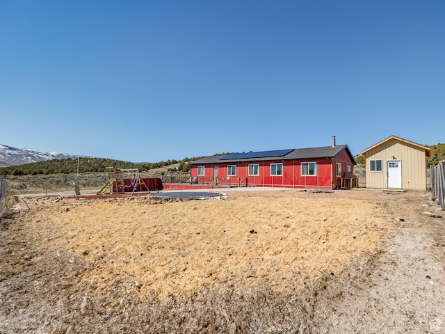 8915 E 33550 N, Fairview, UT 84629 - back of house featuring an outbuilding, roof mounted solar panels, a storage shed, a playground, and fence