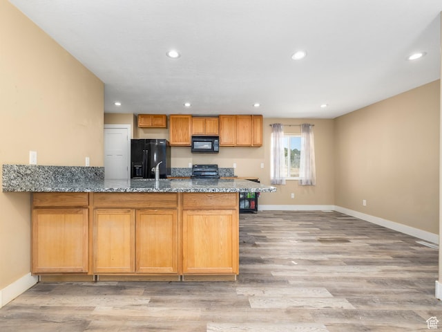 8915 E 33550 N, Fairview, UT 84629 - kitchen with dark stone countertops, a peninsula, recessed lighting, black appliances, and light wood finished floors