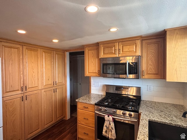 80 S 6000 W, Mendon, UT 84325 - kitchen with dark wood-style flooring, decorative backsplash, light stone counters, and appliances with stainless steel finishes