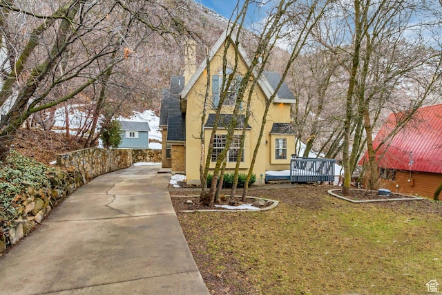 3895 S Grindstone Dr, Springville, UT 84663 - view of front of home with stucco siding, a wooden deck, and a chimney
