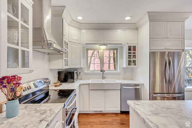 3895 S Grindstone Dr, Springville, UT 84663 - kitchen with light stone countertops, wall chimney range hood, white cabinets, a sink, and stainless steel appliances