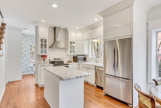 3895 S Grindstone Dr, Springville, UT 84663 - kitchen featuring wall chimney exhaust hood, light wood-style flooring, white cabinets, appliances with stainless steel finishes, and a sink