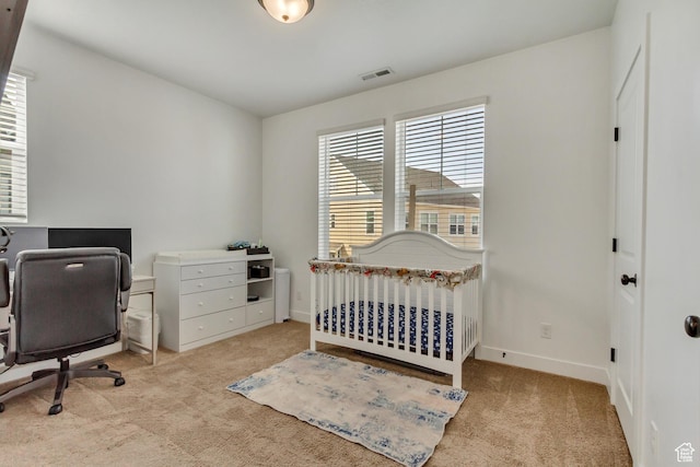 bedroom with carpet flooring, baseboards, visible vents, and a crib