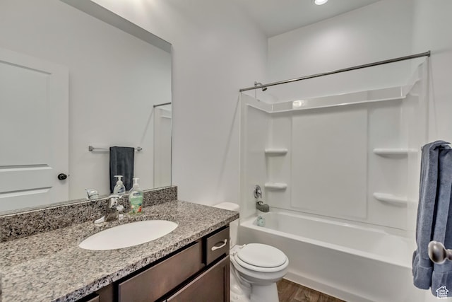 bathroom featuring toilet, vanity, wood finished floors, and shower / bathtub combination