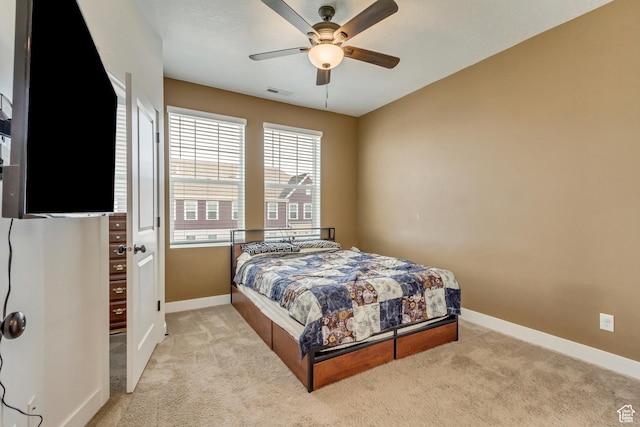 bedroom with visible vents, baseboards, ceiling fan, and light colored carpet