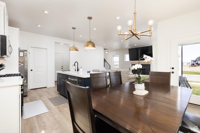 dining space featuring light wood finished floors, a notable chandelier, and recessed lighting