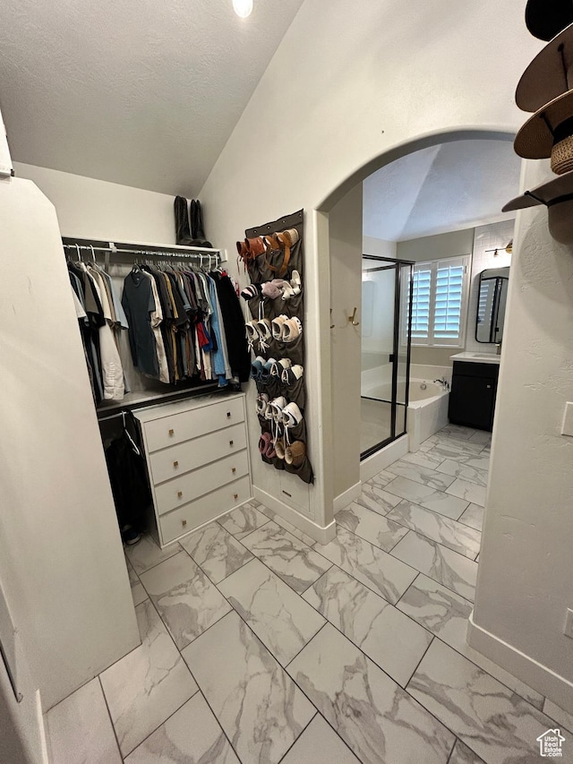 10124 S Autumn Breeze Ln W, South Jordan, UT 84009 - walk in closet featuring arched walkways, marble finish floor, and vaulted ceiling