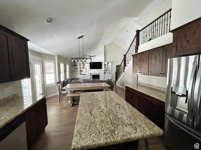 10124 S Autumn Breeze Ln W, South Jordan, UT 84009 - kitchen featuring a center island, dark wood-style flooring, a fireplace, vaulted ceiling, and stainless steel appliances
