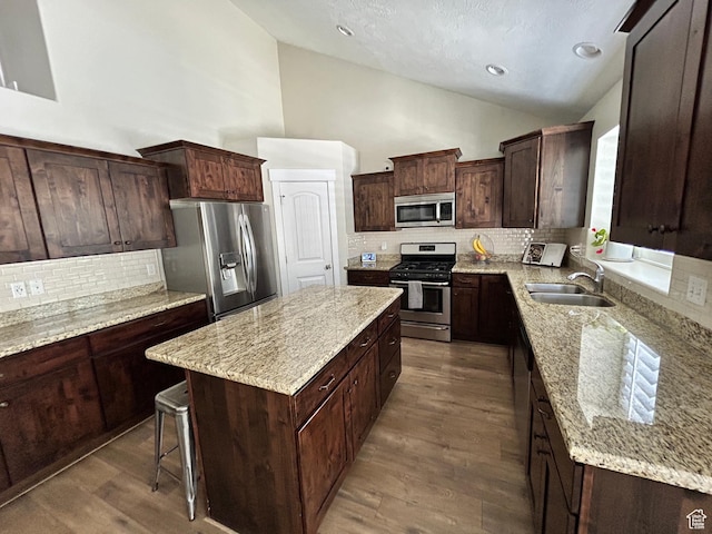 10124 S Autumn Breeze Ln W, South Jordan, UT 84009 - kitchen with dark wood finished floors, a kitchen island, light stone counters, appliances with stainless steel finishes, and a sink