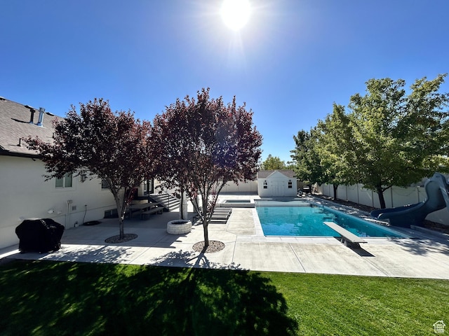 10124 S Autumn Breeze Ln W, South Jordan, UT 84009 - view of pool featuring a diving board, a water slide, a patio area, a fenced backyard, and an outbuilding