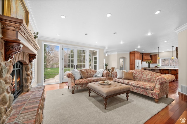 6041 S 2230 E, Holladay, UT 84121 - living area featuring a stone fireplace, visible vents, crown molding, and wood finished floors