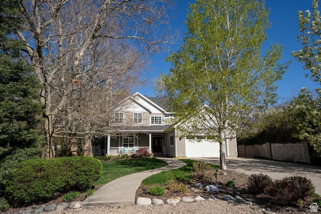 6041 S 2230 E, Holladay, UT 84121 - traditional home with driveway, covered porch, fence, an attached garage, and a front yard