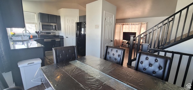 kitchen with a sink, wood finished floors, and appliances with stainless steel finishes