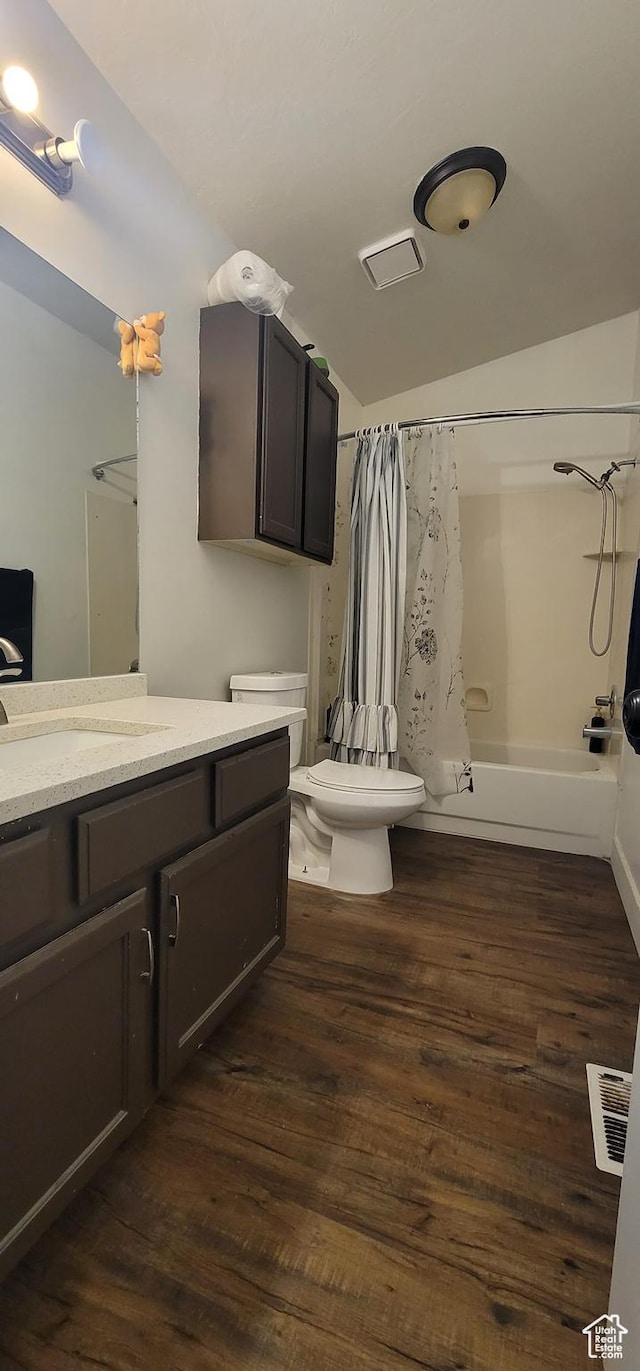 full bathroom with shower / tub combo, toilet, vanity, wood finished floors, and lofted ceiling
