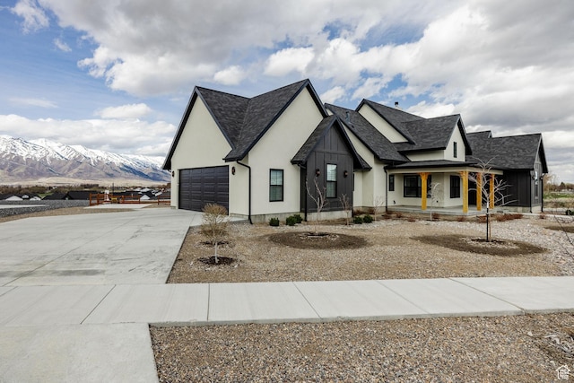 48 S 650 W, Hyrum, UT 84319 - view of front of house featuring concrete driveway, a porch, a mountain view, stucco siding, and an attached garage
