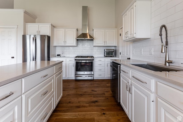 4781 W 4100 S, West Haven, UT 84401 - kitchen with appliances with stainless steel finishes, wall chimney range hood, a sink, tasteful backsplash, and white cabinetry