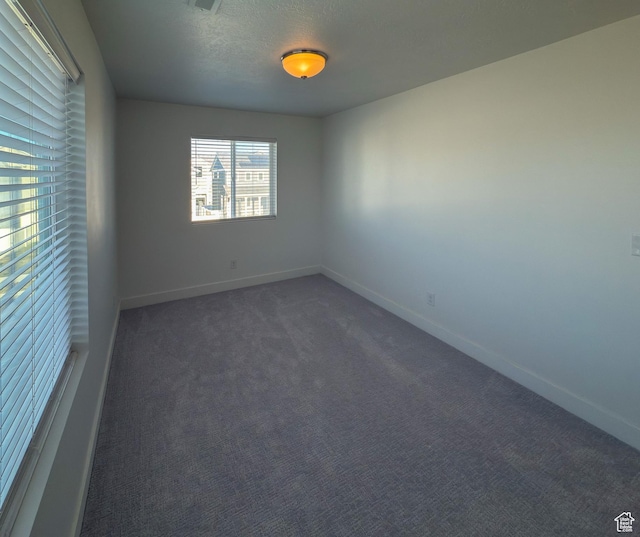 5051 W Bilston Ln S, Herriman, UT 84096 - unfurnished room with baseboards, dark carpet, and a textured ceiling