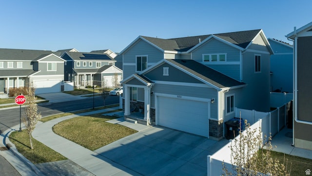 5051 W Bilston Ln S, Herriman, UT 84096 - view of front of home with fence, stone siding, a residential view, and driveway