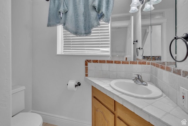 8079 S Juniper Ct, South Weber, UT 84405 - bathroom featuring vanity, baseboards, backsplash, and toilet