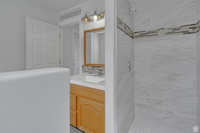 8079 S Juniper Ct, South Weber, UT 84405 - bathroom featuring vanity, a tile shower, and decorative backsplash