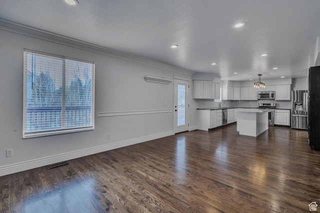8079 S Juniper Ct, South Weber, UT 84405 - unfurnished living room featuring dark wood-style flooring, baseboards, ornamental molding, recessed lighting, and a sink