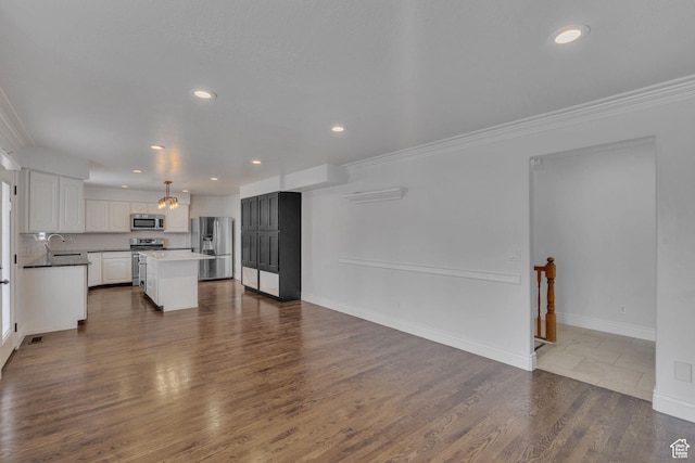 8079 S Juniper Ct, South Weber, UT 84405 - unfurnished living room featuring recessed lighting, dark wood-style floors, a sink, and crown molding