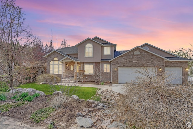 traditional home with roof with shingles, stucco siding, driveway, an attached garage, and a front yard