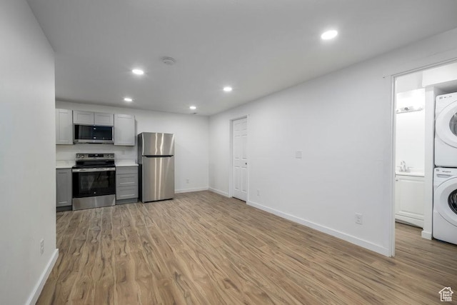 3833 W 1960 N, Lehi, UT 84043 - kitchen with light wood-type flooring, stacked washer and dryer, gray cabinets, appliances with stainless steel finishes, and light countertops