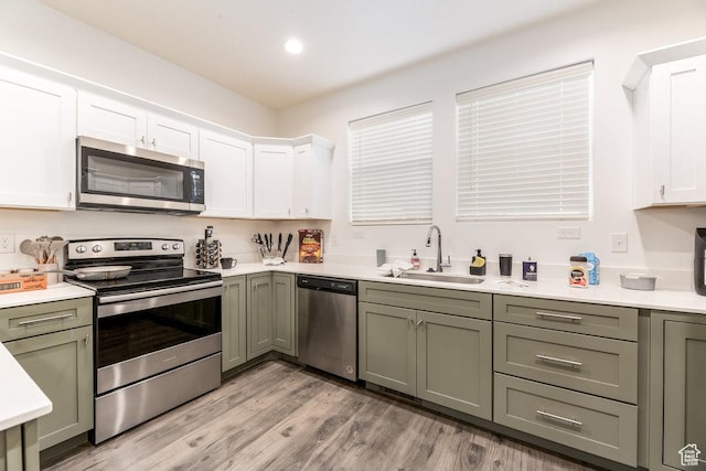 3833 W 1960 N, Lehi, UT 84043 - kitchen featuring light wood-type flooring, white cabinetry, light countertops, a sink, and stainless steel appliances