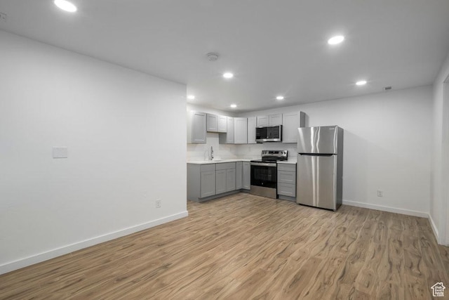 3833 W 1960 N, Lehi, UT 84043 - kitchen featuring light countertops, light wood-style floors, recessed lighting, gray cabinetry, and stainless steel appliances
