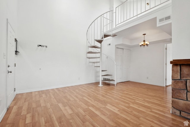 6831 N 2200 W Unit 12K, Park City, UT 84098 - unfurnished living room featuring visible vents, a towering ceiling, light wood-style floors, and stairs