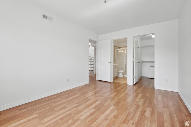 6831 N 2200 W Unit 12K, Park City, UT 84098 - unfurnished bedroom with a walk in closet, visible vents, light wood-type flooring, and baseboards