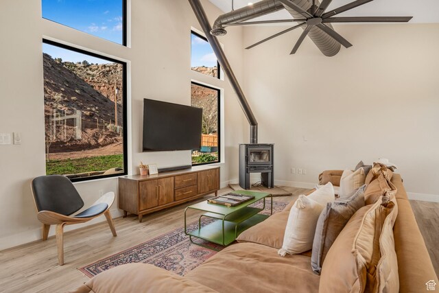160 W Pebble, Rockville, UT 84763 - living area with a wood stove, a ceiling fan, a towering ceiling, plenty of natural light, and baseboards