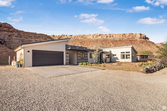 160 W Pebble, Rockville, UT 84763 - view of front of property with driveway, stucco siding, a garage, a mountain view, and solar panels