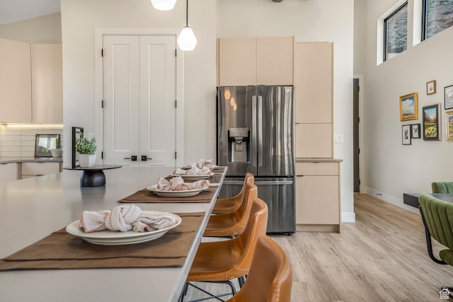 160 W Pebble, Rockville, UT 84763 - kitchen featuring stainless steel fridge, cream cabinetry, light wood-type flooring, a towering ceiling, and pendant lighting