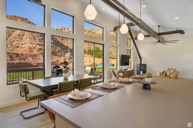 160 W Pebble, Rockville, UT 84763 - dining area featuring a towering ceiling, healthy amount of natural light, light wood finished floors, baseboards, and a wood stove